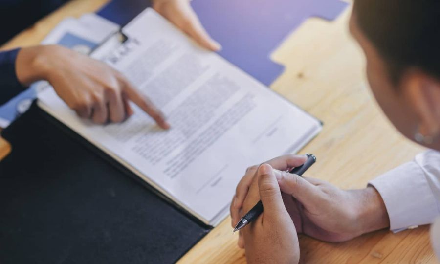 un homme daffaires examine les termes et conditions avant de signer un document