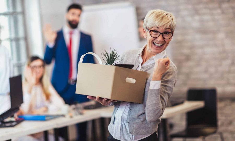 femme employée âgée quittant le bureau avec une boîte